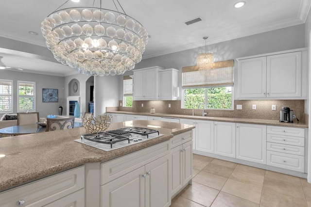 kitchen with stainless steel gas stovetop, a healthy amount of sunlight, and backsplash