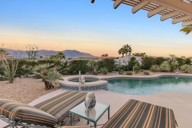 pool at dusk featuring a pergola, an in ground hot tub, a mountain view, and a patio