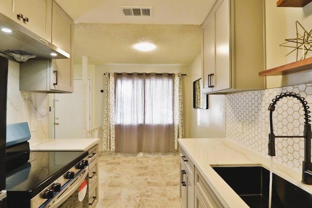 kitchen with cream cabinets, sink, backsplash, electric range, and light stone countertops