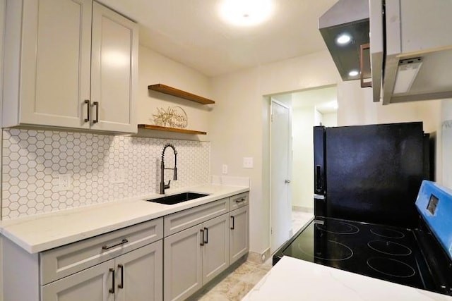 kitchen with sink, stainless steel range with electric stovetop, black refrigerator, gray cabinets, and decorative backsplash