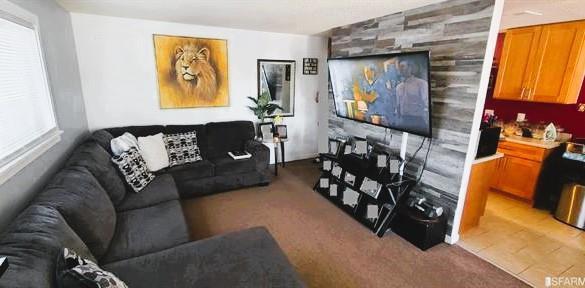 living room featuring light tile patterned floors and wood walls