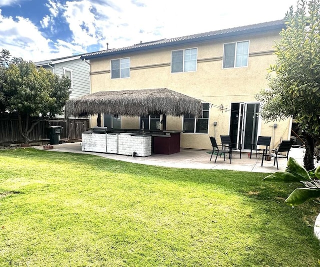 rear view of house featuring a yard, an outdoor kitchen, an outdoor bar, and a patio area