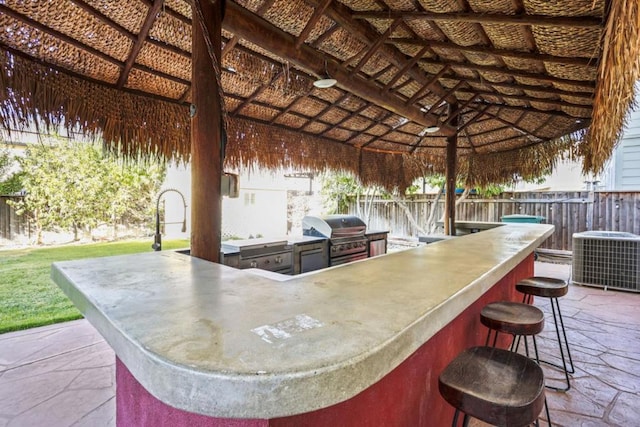 view of patio featuring an outdoor kitchen, a grill, cooling unit, a gazebo, and a bar