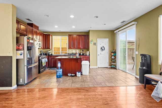 kitchen featuring a kitchen island, light wood-type flooring, and stainless steel appliances