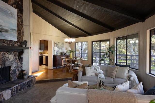 carpeted living room featuring beam ceiling, a chandelier, wooden ceiling, wooden walls, and a fireplace