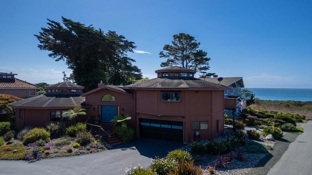 view of front facade featuring a garage and a water view