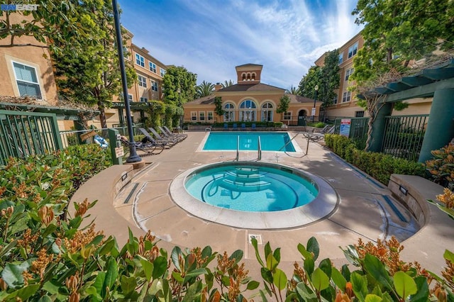 view of swimming pool featuring a patio, a pergola, and a hot tub