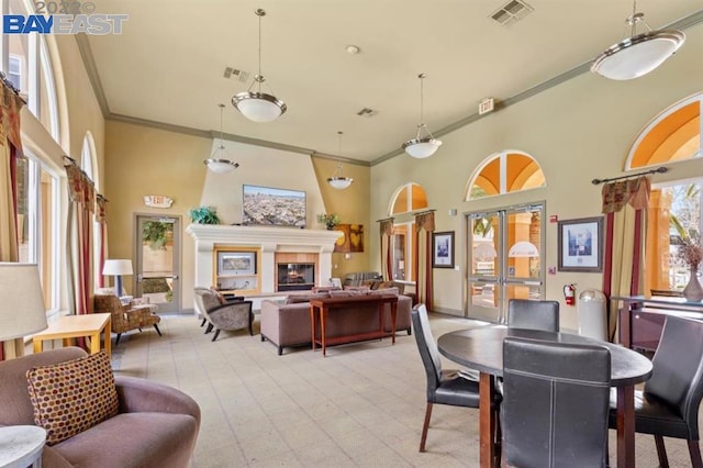 dining room featuring french doors, a towering ceiling, and ornamental molding