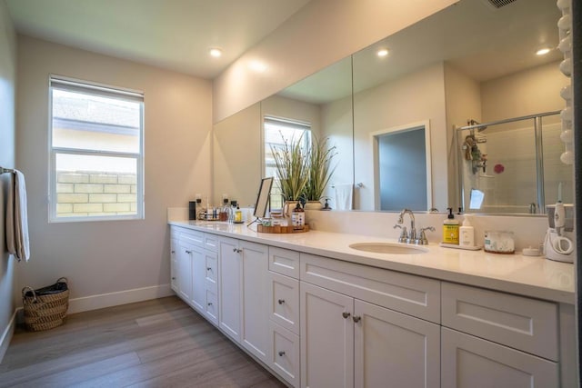 bathroom featuring hardwood / wood-style flooring, plenty of natural light, an enclosed shower, and vanity