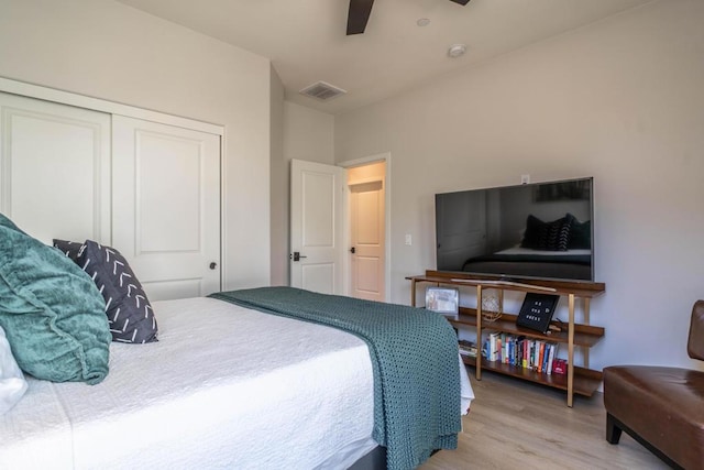 bedroom with light wood-type flooring, a closet, and ceiling fan