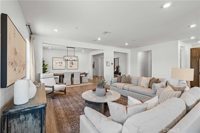 living room with hardwood / wood-style flooring and an inviting chandelier