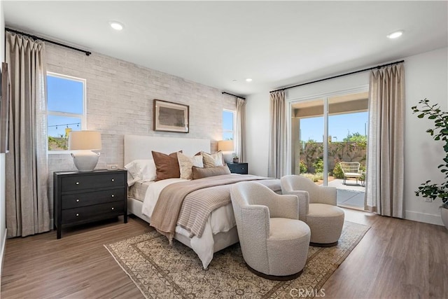 bedroom with access to exterior and wood-type flooring