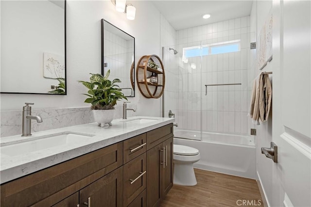 full bathroom with vanity, wood-type flooring, tiled shower / bath combo, and toilet