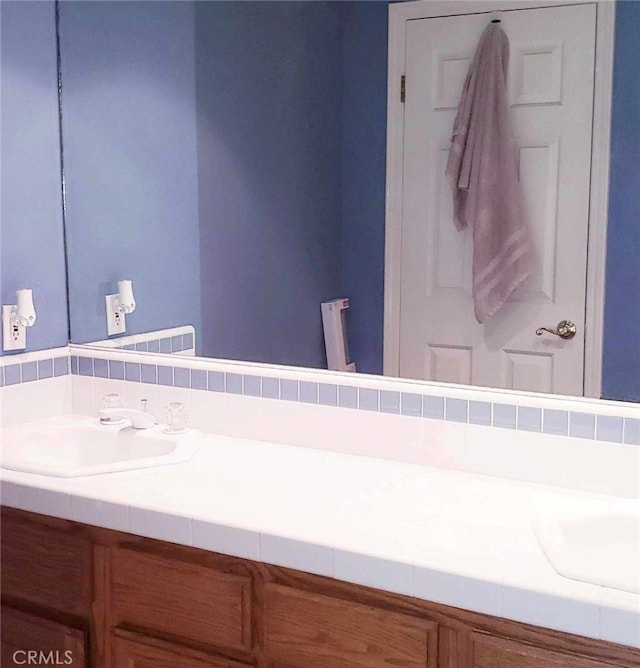 bathroom featuring vanity and tasteful backsplash