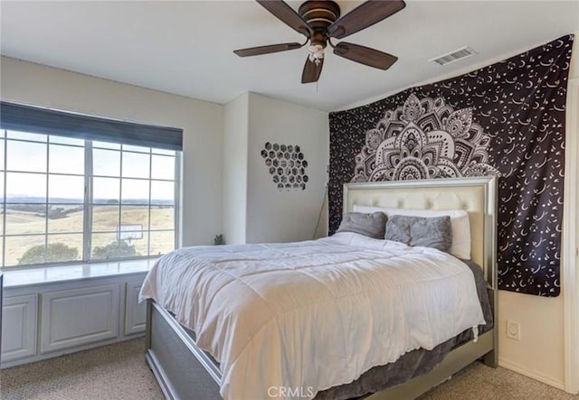 bedroom with multiple windows, light colored carpet, and ceiling fan