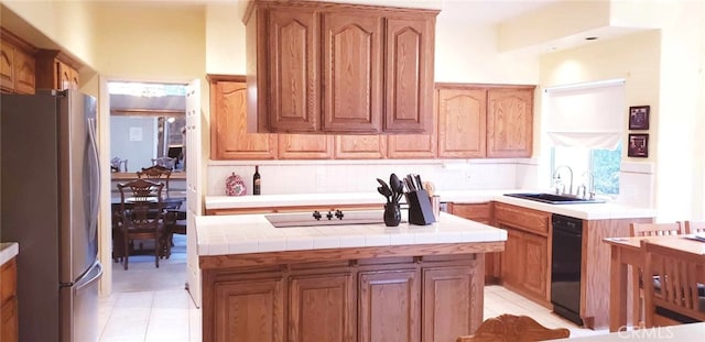 kitchen with stainless steel fridge, tile counters, a kitchen island, and light tile patterned floors