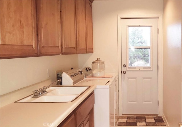 laundry area featuring cabinets, sink, and washing machine and clothes dryer