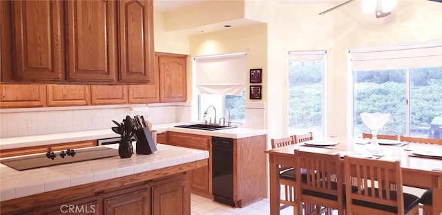 kitchen with decorative backsplash, tile counters, sink, and light tile patterned floors