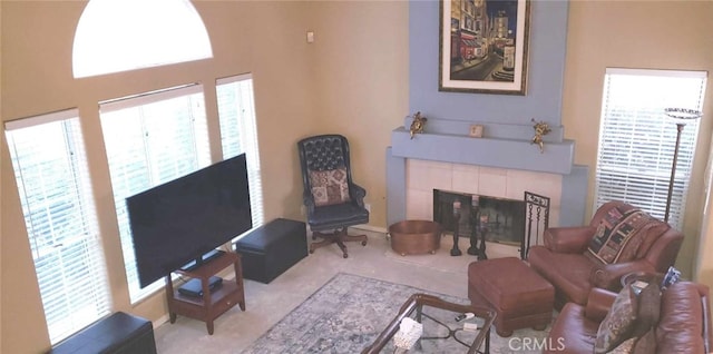 living room featuring a tile fireplace and carpet flooring