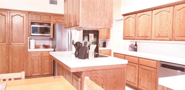 kitchen with a center island, backsplash, and appliances with stainless steel finishes