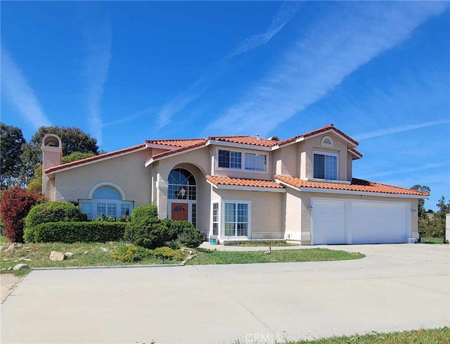 mediterranean / spanish-style house with a garage