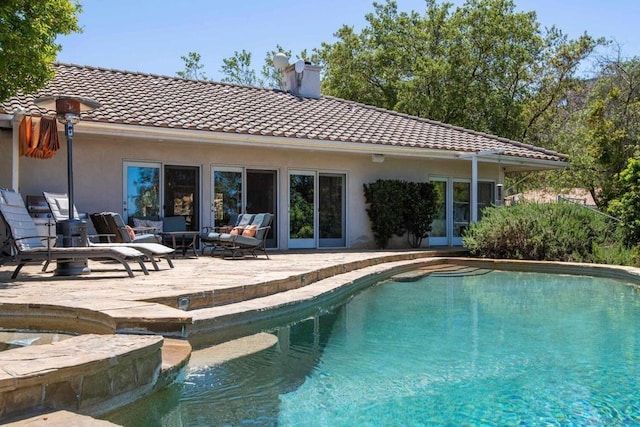 view of pool with an in ground hot tub, outdoor lounge area, and a patio area