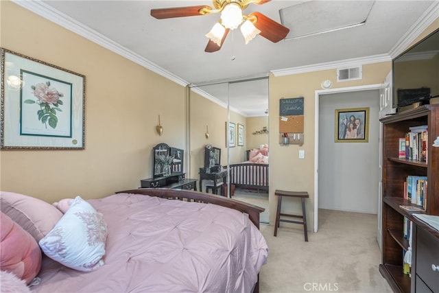 carpeted bedroom featuring a closet, crown molding, and ceiling fan