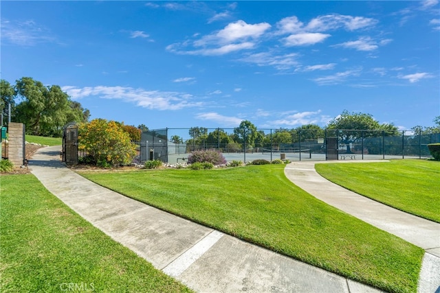 surrounding community with a yard and tennis court