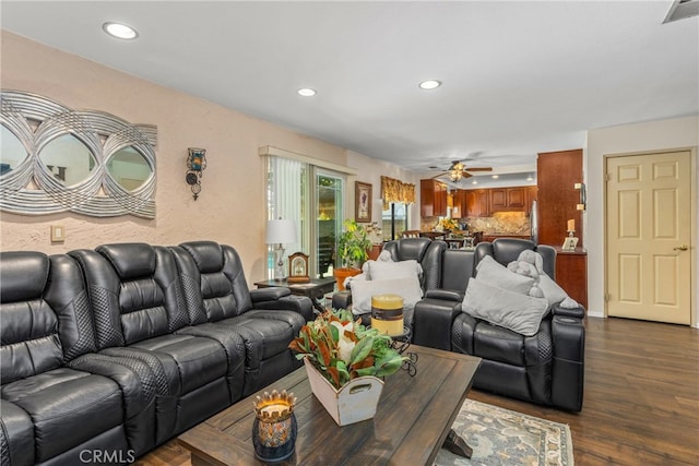 living room featuring ceiling fan and dark hardwood / wood-style flooring