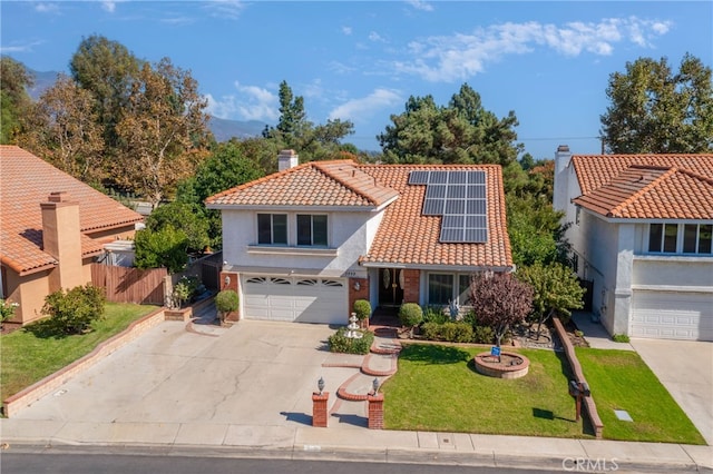 mediterranean / spanish-style house with a garage, a front lawn, and solar panels