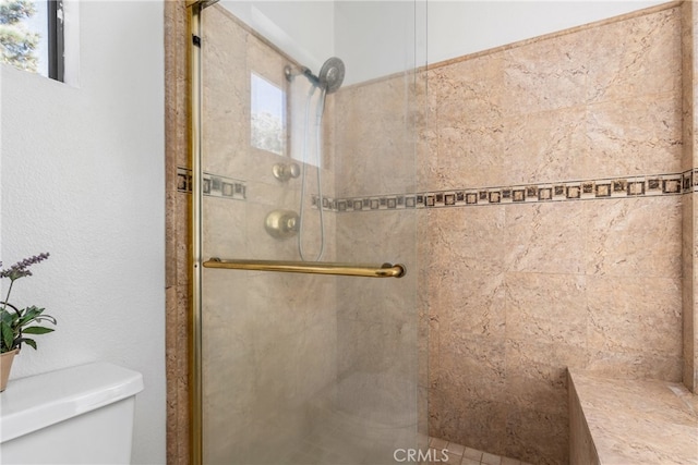 bathroom featuring toilet and an enclosed shower