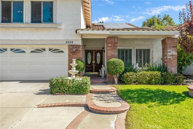 property entrance featuring a garage and a lawn