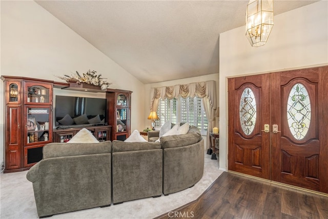 entryway with dark wood-type flooring, a notable chandelier, a textured ceiling, and high vaulted ceiling