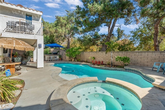 view of swimming pool featuring a patio area and an in ground hot tub