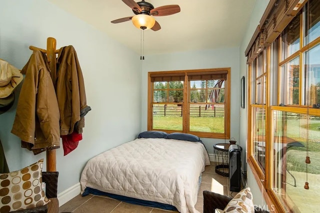 tiled bedroom featuring ceiling fan