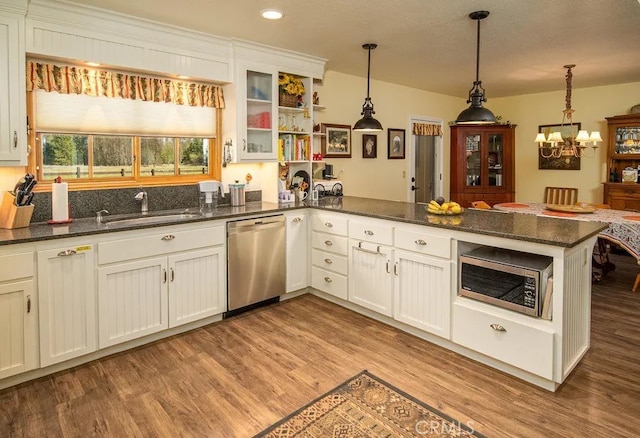 kitchen with white cabinetry, appliances with stainless steel finishes, and pendant lighting