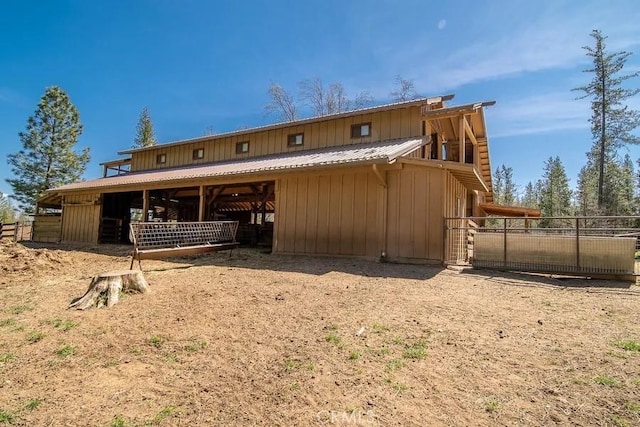 rear view of house featuring an outdoor structure, metal roof, and an exterior structure