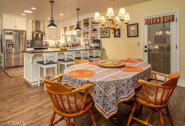 dining space with light hardwood / wood-style floors, an inviting chandelier, and sink