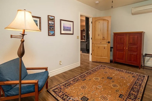 living area with a wall mounted AC and dark hardwood / wood-style flooring