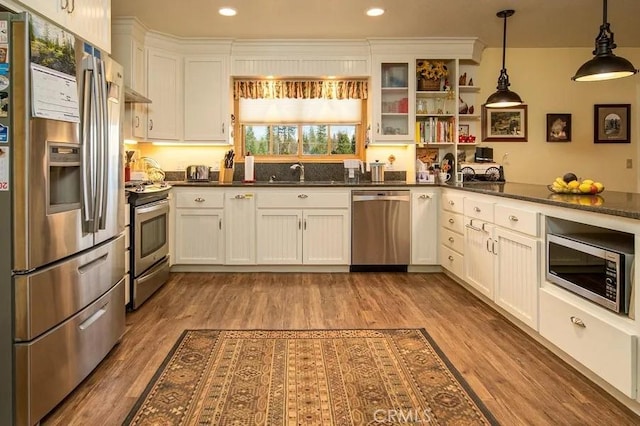 kitchen featuring light wood-style floors, dark countertops, and stainless steel appliances
