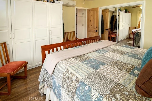 bedroom featuring a wall unit AC and dark wood-type flooring