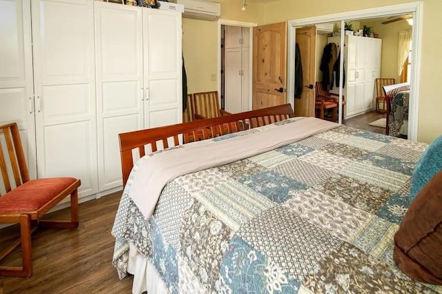 bedroom featuring wood finished floors, a wall unit AC, and a closet