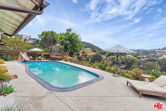 view of pool with a patio and a water slide