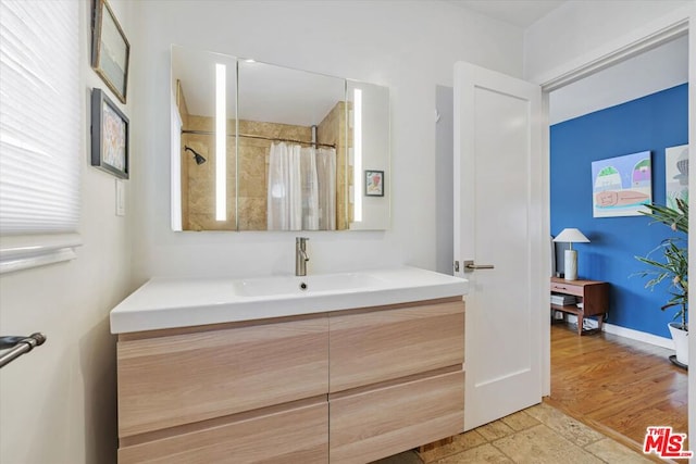 bathroom featuring curtained shower, vanity, and wood-type flooring