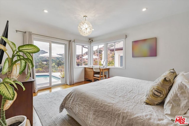 bedroom with access to outside, a chandelier, and light wood-type flooring