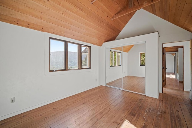 interior space with lofted ceiling with beams, wood ceiling, a mountain view, and hardwood / wood-style flooring