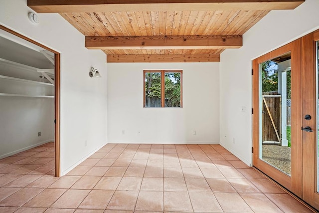 tiled spare room featuring wooden ceiling, beam ceiling, and plenty of natural light