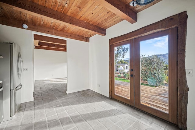 spare room with wooden ceiling, a mountain view, beam ceiling, and french doors