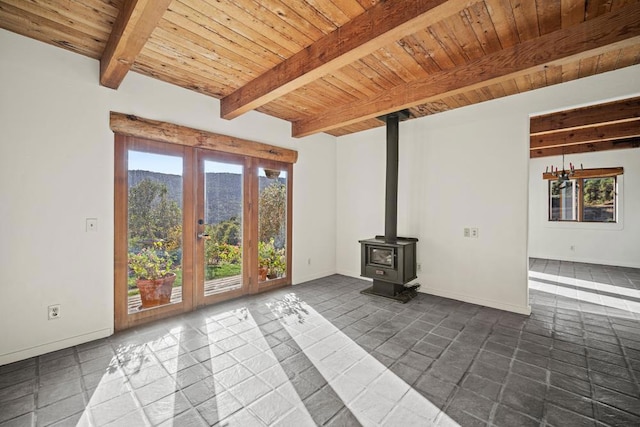 unfurnished living room featuring wood ceiling, beam ceiling, a wood stove, and french doors