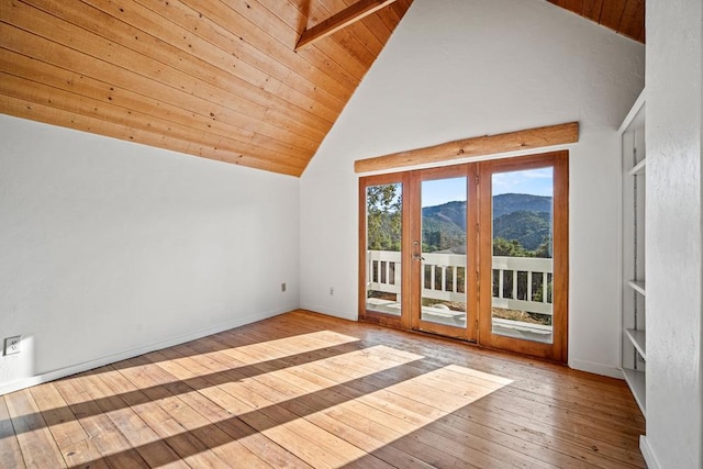 additional living space featuring beamed ceiling, high vaulted ceiling, light wood-type flooring, a mountain view, and wooden ceiling